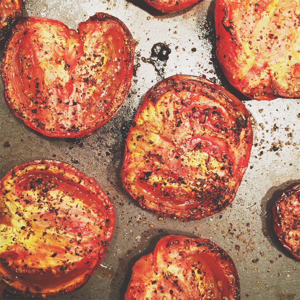 A sheetpan of halved tomatoes, roasted to perfection.