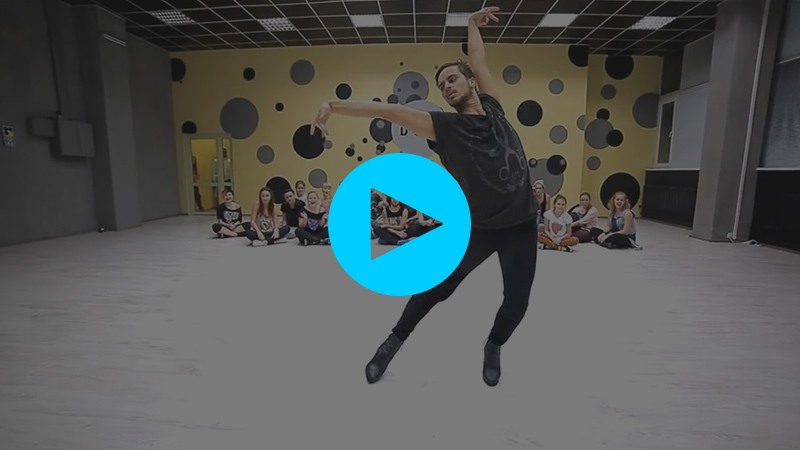 A screenshot from Youtube of Yanis Marshall mid-pose. He is in a dance class and is wearing heels.