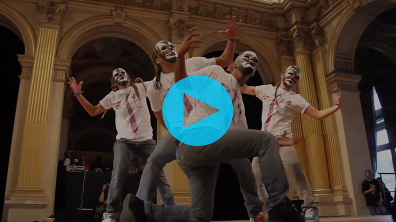 Four dancers create a formation and turn their creepy clown masked-faces out to the audience during a beat drop.