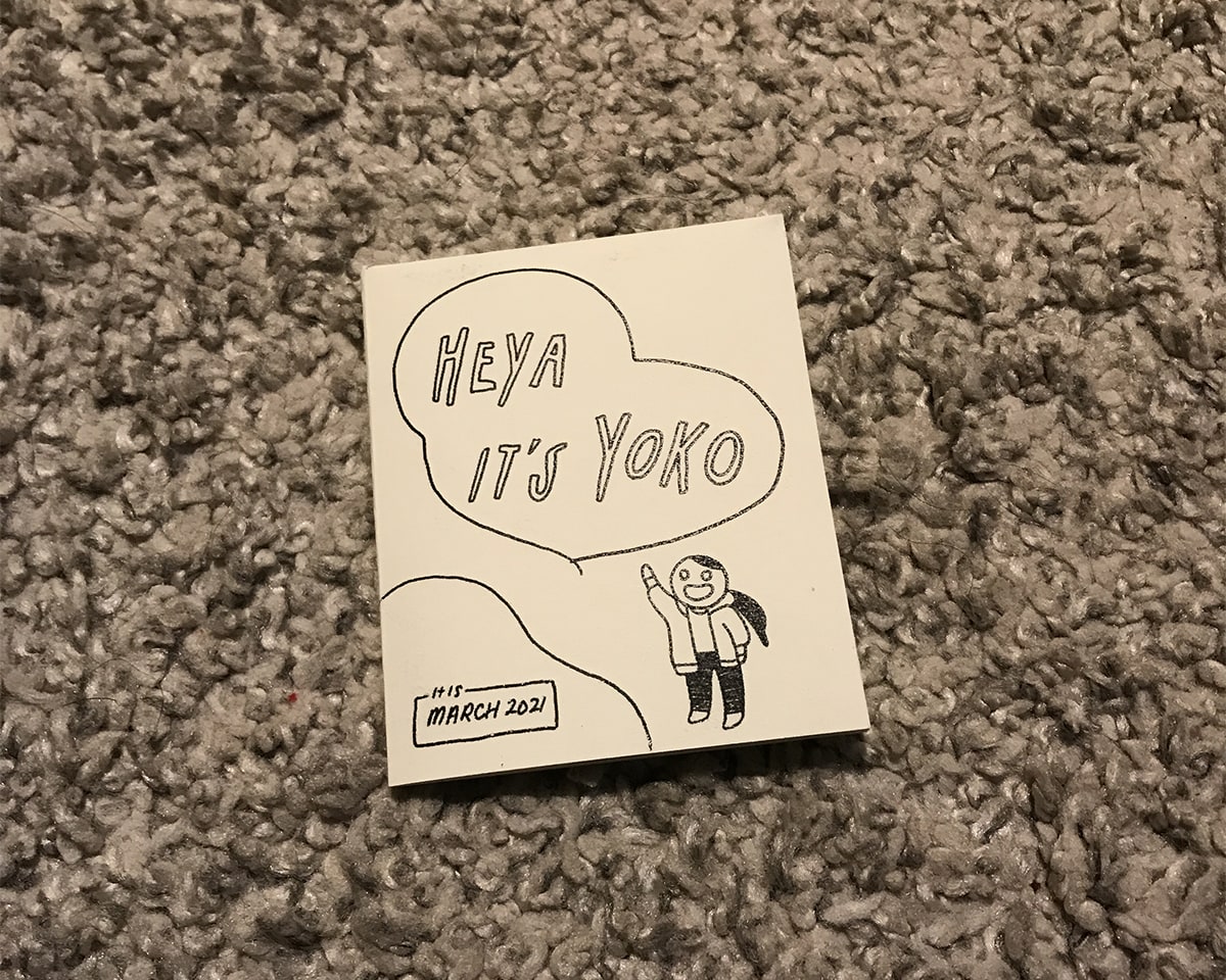 Photo of the zine’s front cover. It’s an illustration of me saying HEYA IT’S YOKO